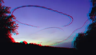 A purple sky looks blue when seen through 3D anaglyph glasses. There are three trails of bats: two nice curves, one wiggly dotted line. Those were made by different species of bats.