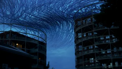 Black and deeply blue image, shot just after dusk. The flock arrives at the apartment buildings from afar, and navigates in an S curve between the two buildings. Some windows reflect what is left of the sunset, in green. The focus is unusual, as the plane lies nearly parallel to the flight pattern. There is a dreamy atmosphere to this image.