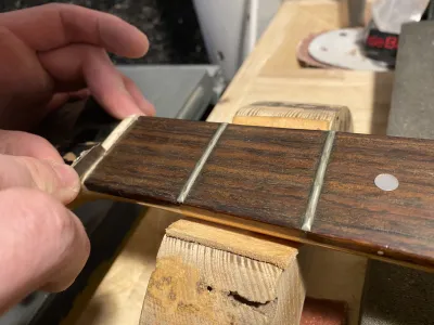 Each fret and the comb are cut loose from the fretboard before they are removed. Pelle is doing this with an exacto type knife.