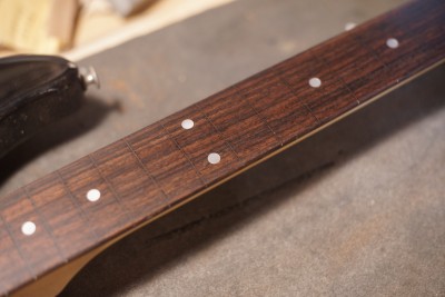 Close up of the fretless neck. The gaps have been filled an the neck looks really smooth. It runs diagonally through the frame. 