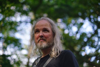 Photo of a dude with long grey hair (me) in a forest (natural habitat)