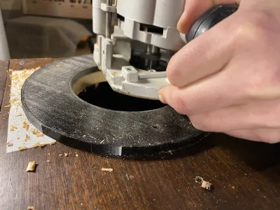 Pelle grinding the hole. On the box is a black 3D printed circle, other diameter similar to a 7” single record, the inside has an 111.7mm wide hole. The sleeve holder fits in this exactly.