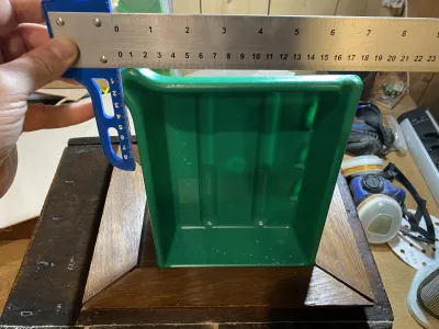Measuring what the size of the door should be, so the development trays can be slid into the camera without spoiling the chemicals. The images show the frame of the door, a dev tray in an upright position, and a measuring tool.
